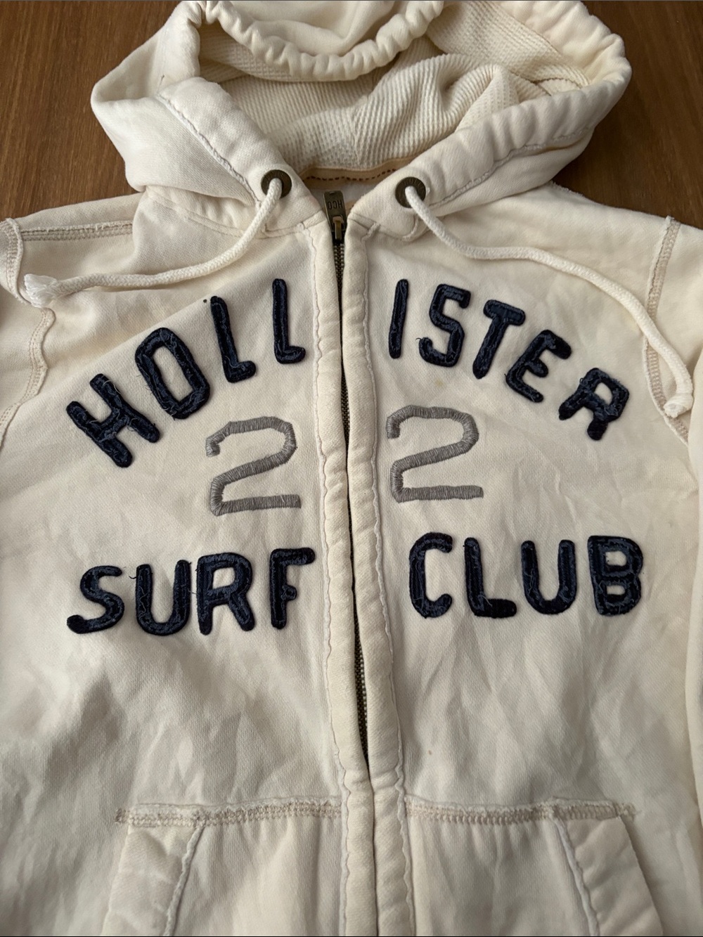 Hollister Cream Hooded Zip Jacket with Navy & Gray Appliqué